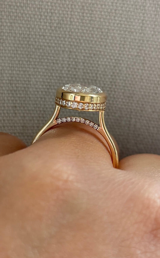 The Shae - 5.5ctw Oval Lab Grown Diamond Bezel Ring with a Peekaboo Halo