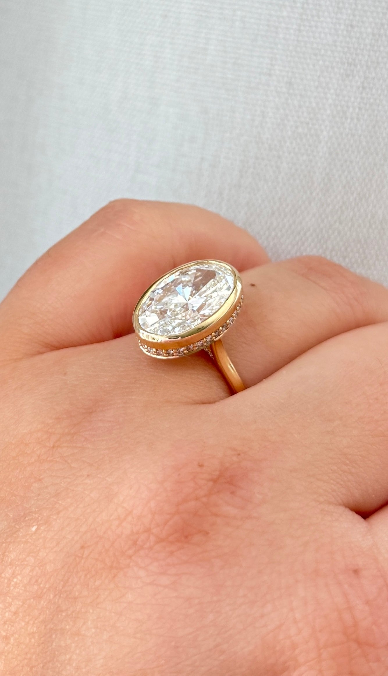 The Shae - 5.5ctw Oval Lab Grown Diamond Bezel Ring with a Peekaboo Halo